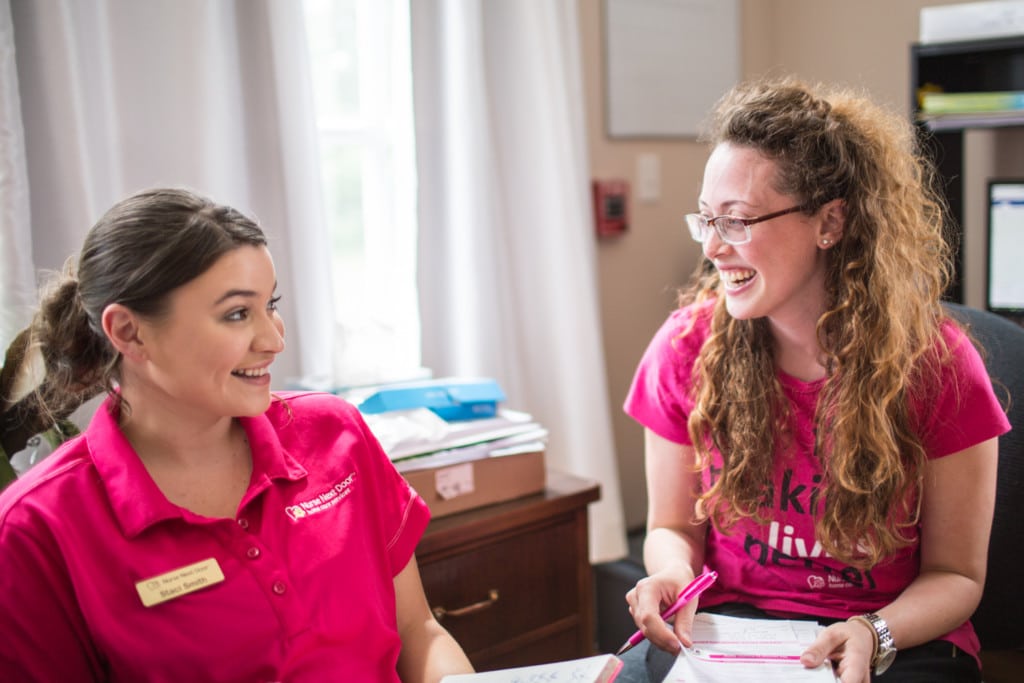 A Nurse Next Door Registered Nurse and business owner talks with her staff about the care delivery program for a client